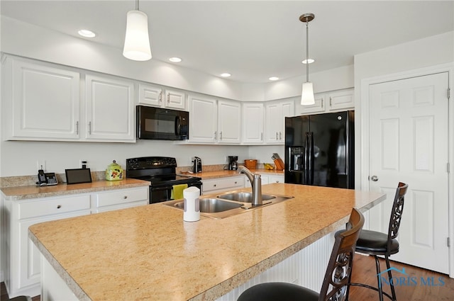 kitchen featuring black appliances, a sink, white cabinets, and dark wood-type flooring