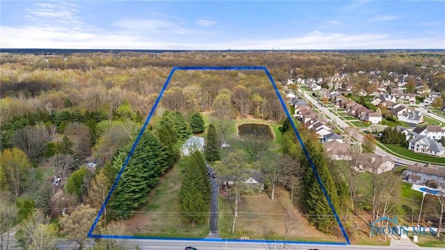 birds eye view of property featuring a wooded view and a residential view
