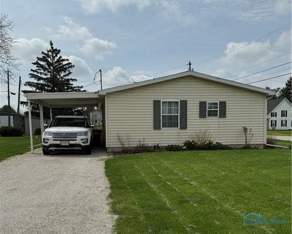 429 W Main St, Delta, OH 43515 - view of front facade with aphalt driveway, a carport, and a front lawn