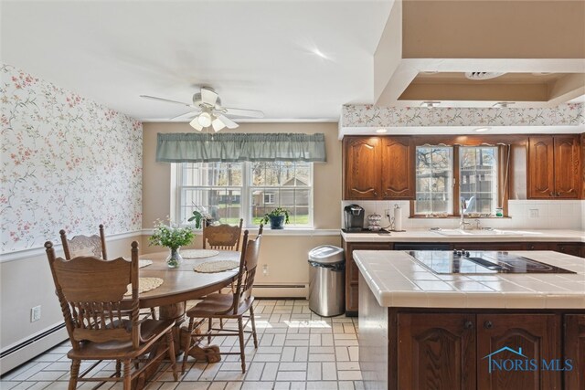 124 Miller Ave, Archbold, OH 43502 - kitchen featuring a baseboard radiator, a sink, tile counters, and wallpapered walls