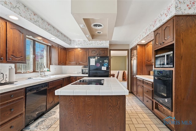 124 Miller Ave, Archbold, OH 43502 - kitchen with black appliances, a sink, tile countertops, and a kitchen island