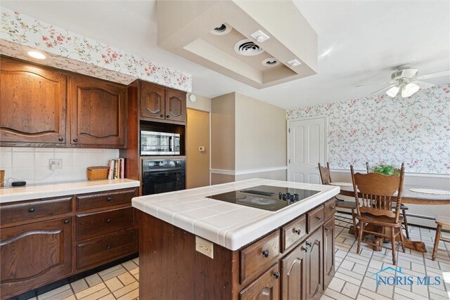 124 Miller Ave, Archbold, OH 43502 - kitchen with black appliances, tile counters, a ceiling fan, wallpapered walls, and a raised ceiling