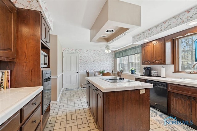 124 Miller Ave, Archbold, OH 43502 - kitchen with tile countertops, black appliances, wallpapered walls, a sink, and a center island