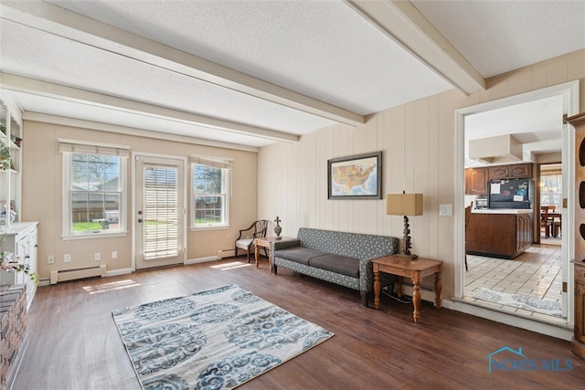 124 Miller Ave, Archbold, OH 43502 - living area featuring baseboard heating, wood finished floors, beamed ceiling, a textured ceiling, and baseboards