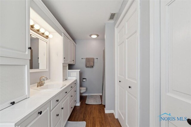 124 Miller Ave, Archbold, OH 43502 - bathroom with toilet, vanity, wood finished floors, and baseboards
