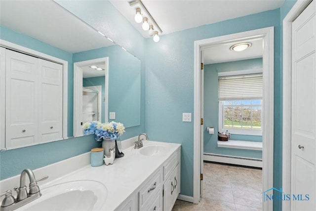 124 Miller Ave, Archbold, OH 43502 - bathroom featuring a baseboard radiator, double vanity, tile patterned floors, and baseboards