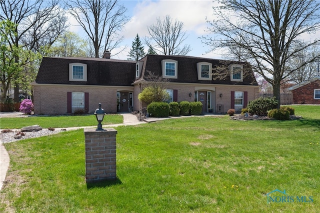 124 Miller Ave, Archbold, OH 43502 - front of property with mansard roof, brick siding, roof with shingles, and a front yard
