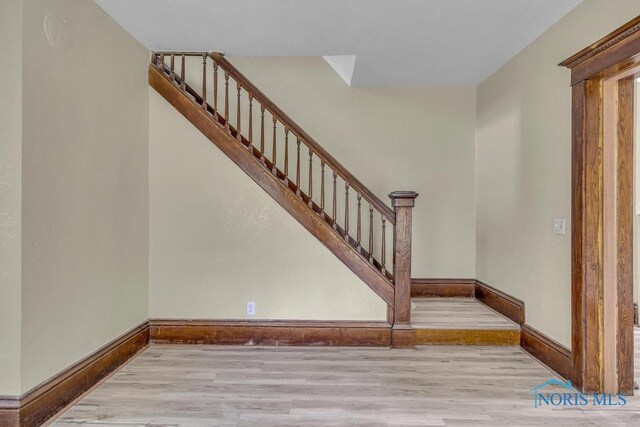 stairway with baseboards and wood finished floors