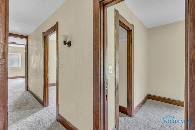 corridor with carpet floors and baseboards