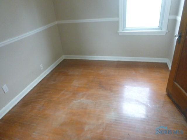 unfurnished room featuring baseboards and light wood-style flooring