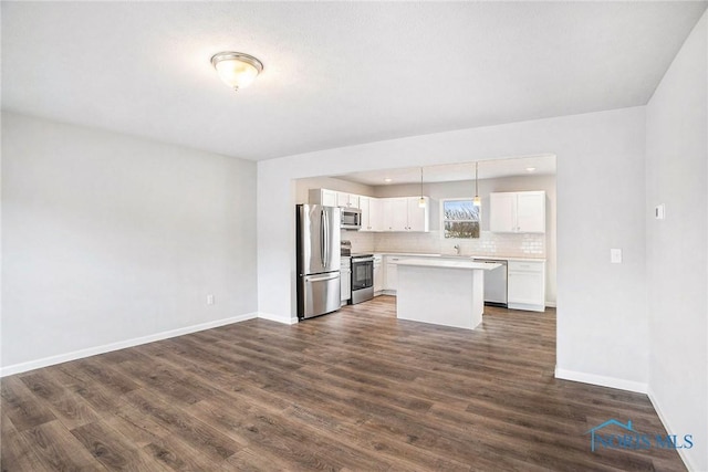 kitchen featuring baseboards, dark wood-type flooring, light countertops, white cabinets, and appliances with stainless steel finishes