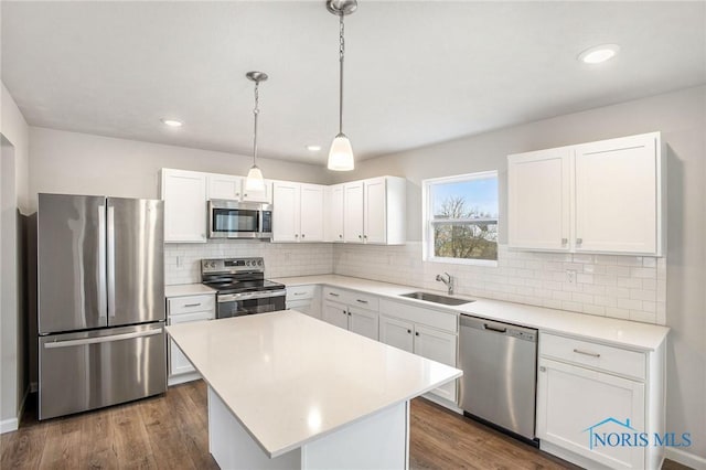 kitchen featuring stainless steel appliances, white cabinetry, a sink, and tasteful backsplash