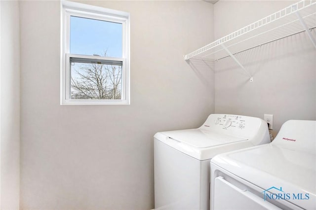 clothes washing area featuring laundry area and washer and clothes dryer