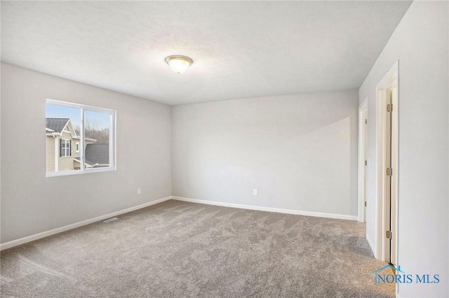 empty room featuring baseboards and carpet