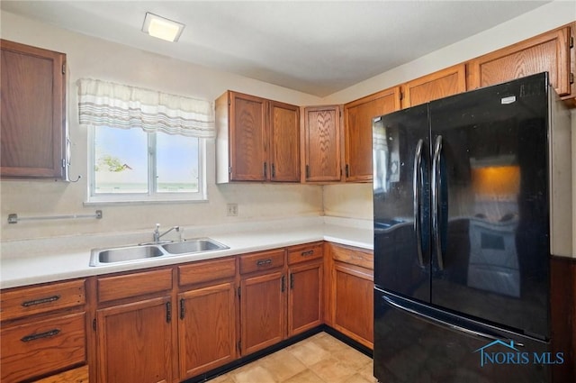 13417 Center St, Weston, OH 43569 - kitchen featuring brown cabinets, a sink, freestanding refrigerator, and light countertops