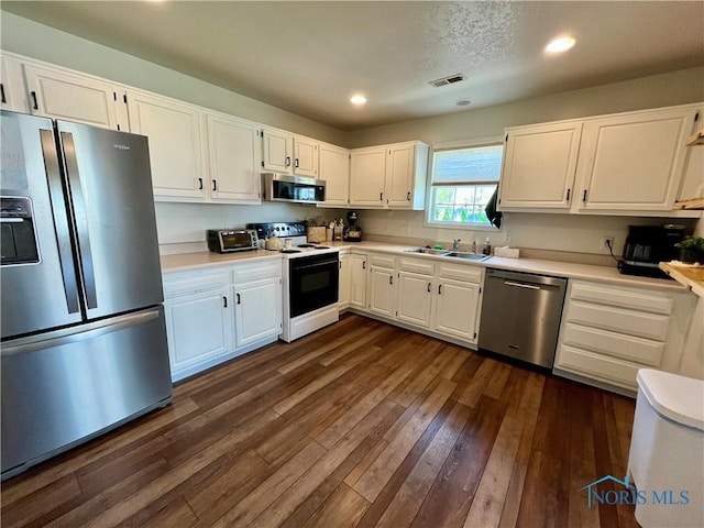 kitchen with stainless steel appliances, light countertops, a sink, white cabinetry, and visible vents