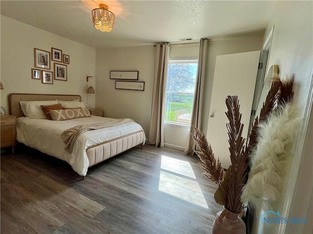 bedroom with visible vents and wood finished floors