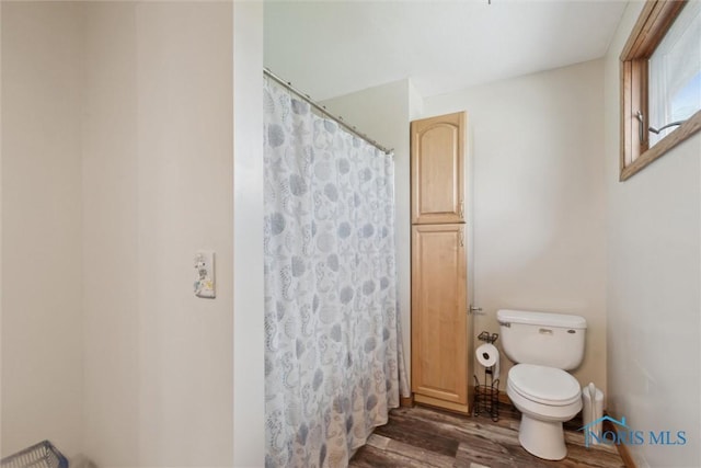 full bathroom with toilet, wood finished floors, and a shower with shower curtain