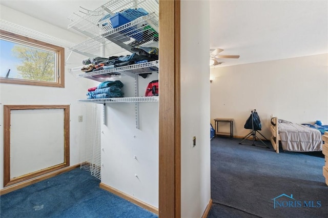 interior space featuring baseboards, a ceiling fan, and carpet flooring