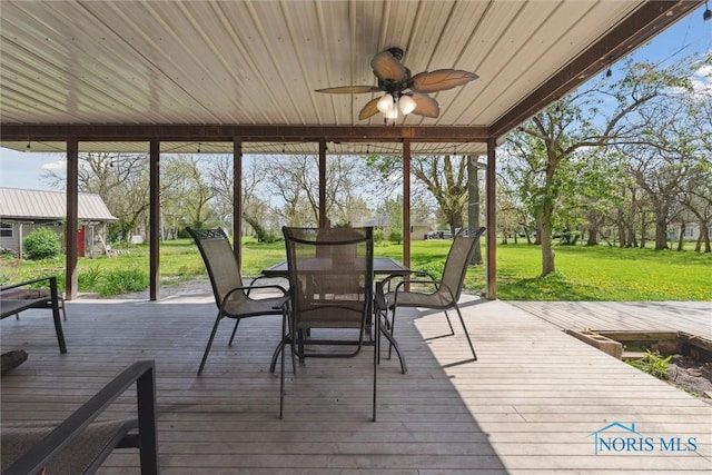 sunroom featuring a ceiling fan, outdoor dining space, and a healthy amount of sunlight