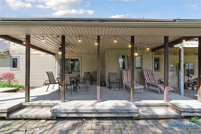 view of patio with a ceiling fan, a wooden deck, and outdoor dining space