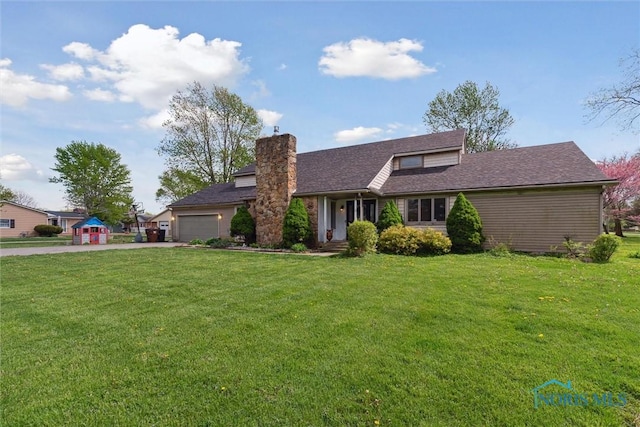 view of front facade with a chimney, an attached garage, driveway, and a front yard