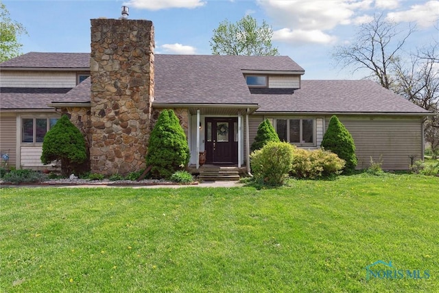 view of front of property featuring a chimney, a shingled roof, and a front yard
