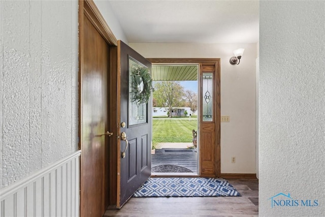 foyer entrance featuring a textured wall and wood finished floors