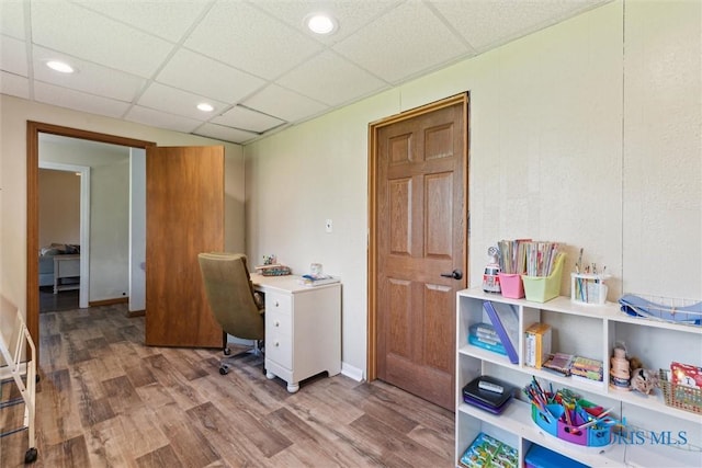 office space with a drop ceiling and wood finished floors