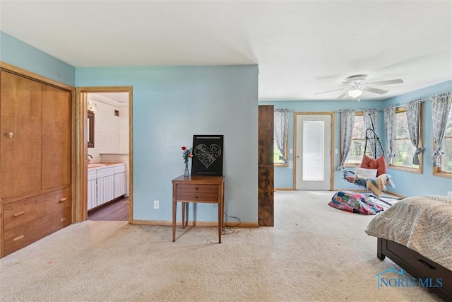 carpeted bedroom with baseboards, a sink, connected bathroom, and ceiling fan