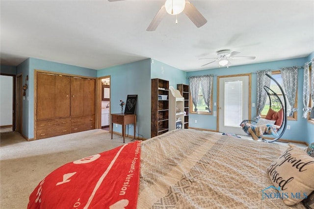 carpeted bedroom featuring baseboards, a ceiling fan, and a closet