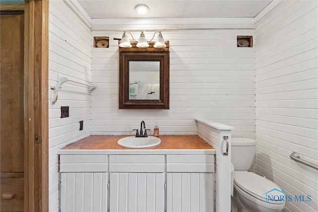 half bath featuring vanity and toilet