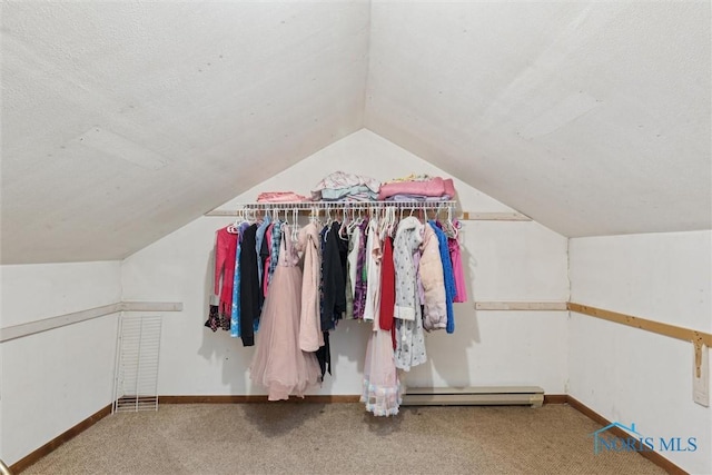 walk in closet with carpet floors, a baseboard heating unit, and vaulted ceiling