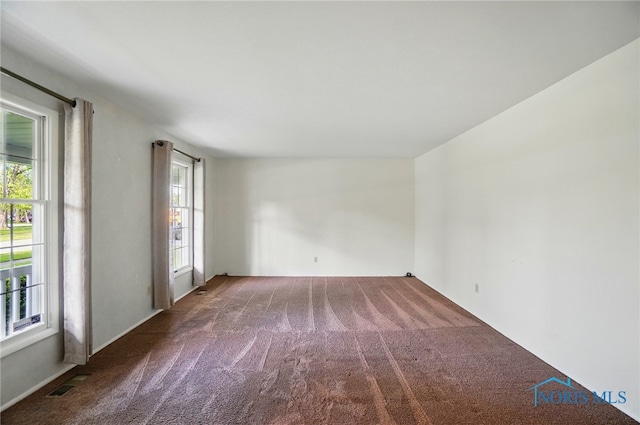unfurnished room featuring carpet and visible vents