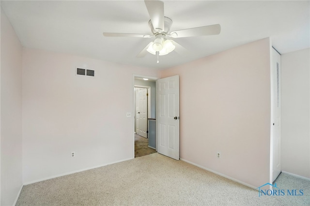 unfurnished bedroom featuring baseboards, carpet, a ceiling fan, and visible vents