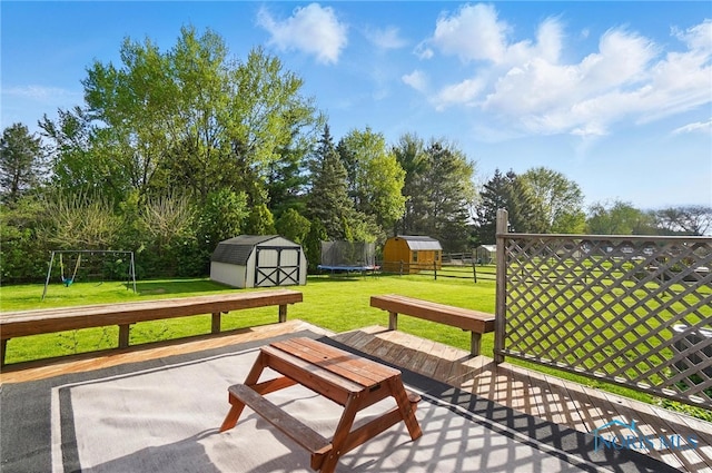 surrounding community with a storage shed, fence, an outdoor structure, a playground, and a yard