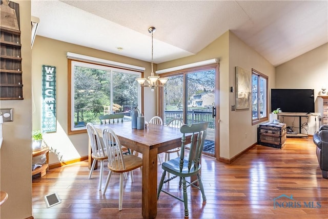 dining space featuring baseboards, wood-type flooring, and lofted ceiling