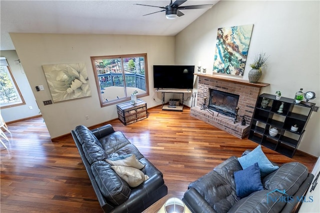 living area with a wealth of natural light, wood finished floors, a ceiling fan, and vaulted ceiling