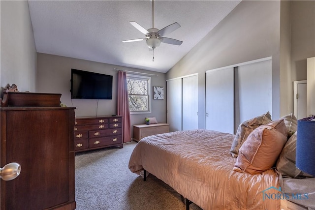 bedroom with multiple closets, ceiling fan, lofted ceiling, and carpet flooring