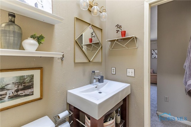 half bath featuring toilet and a sink