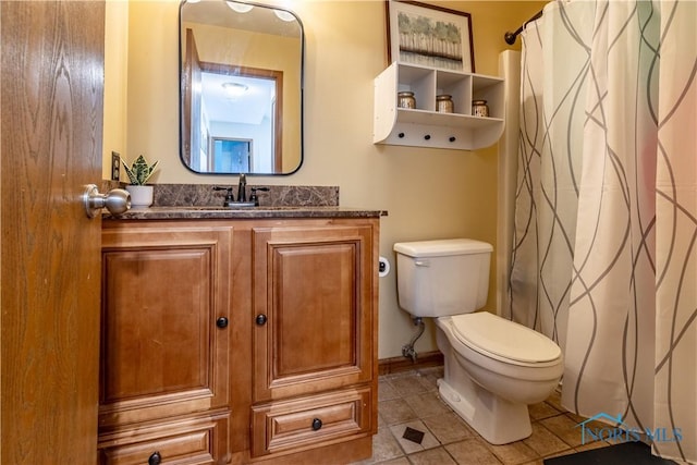 bathroom featuring a shower with curtain, baseboards, toilet, vanity, and tile patterned flooring