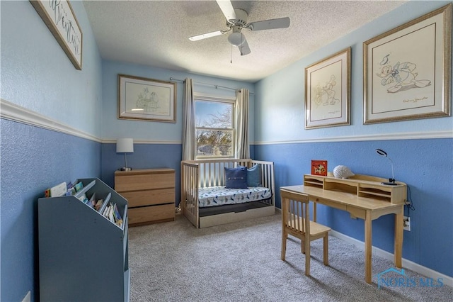 bedroom featuring a textured ceiling, a textured wall, baseboards, carpet, and a ceiling fan