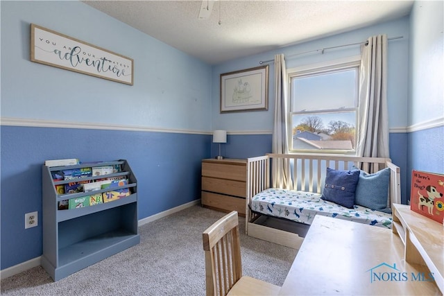 bedroom featuring a textured ceiling, carpet, and baseboards