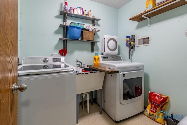 clothes washing area with washer and dryer, visible vents, and laundry area