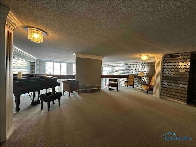 sitting room featuring a textured ceiling, ornamental molding, carpet flooring, and decorative columns