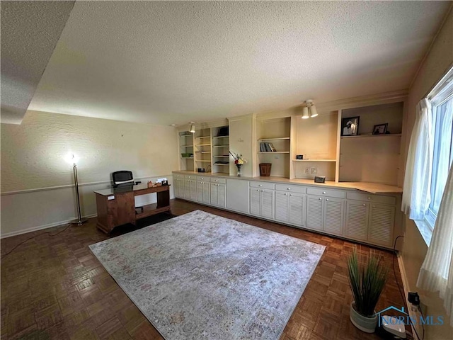 home office featuring a textured ceiling and baseboards