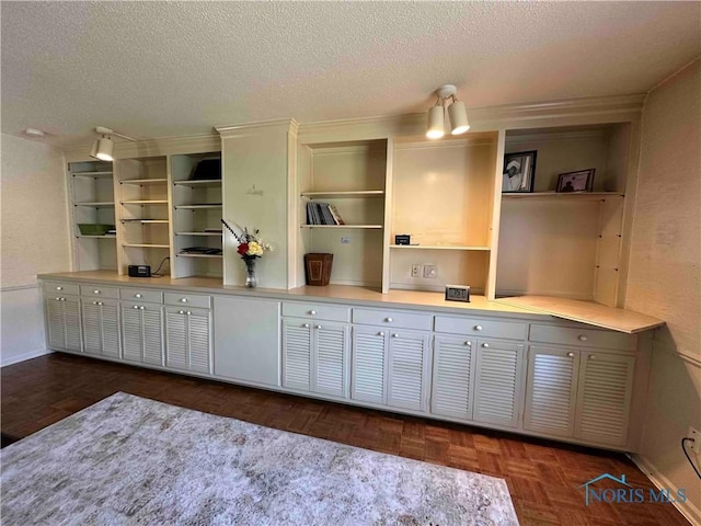 kitchen with a textured ceiling, open shelves, and baseboards