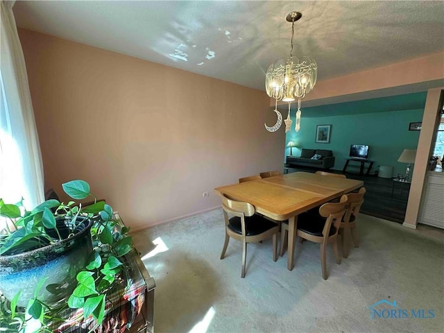 dining area featuring a chandelier and light colored carpet