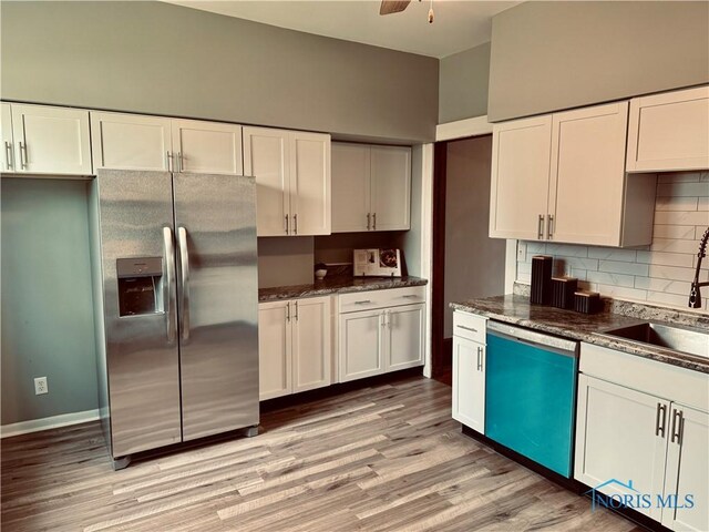 kitchen featuring tasteful backsplash, a sink, dishwasher, light wood finished floors, and stainless steel refrigerator with ice dispenser