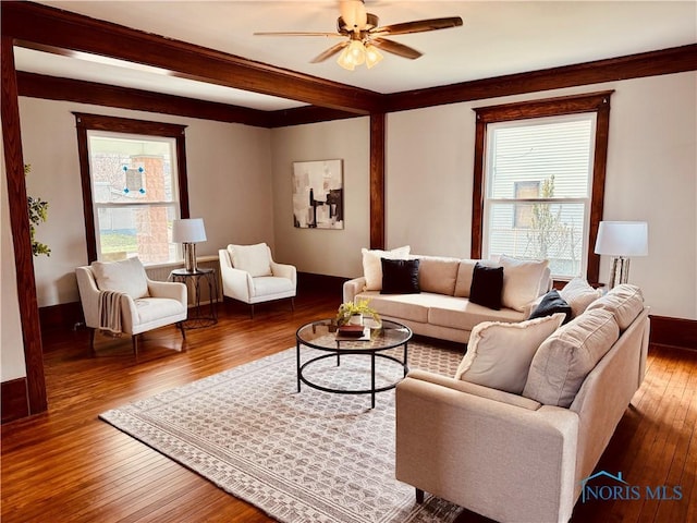 living area with a ceiling fan, wood finished floors, and baseboards